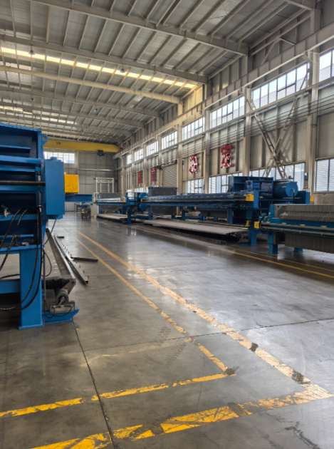 鄭州樸華科技現(xiàn)代化的環(huán)保設備生產(chǎn)基地內(nèi)部，展示加工設備和組裝中的大型壓濾機